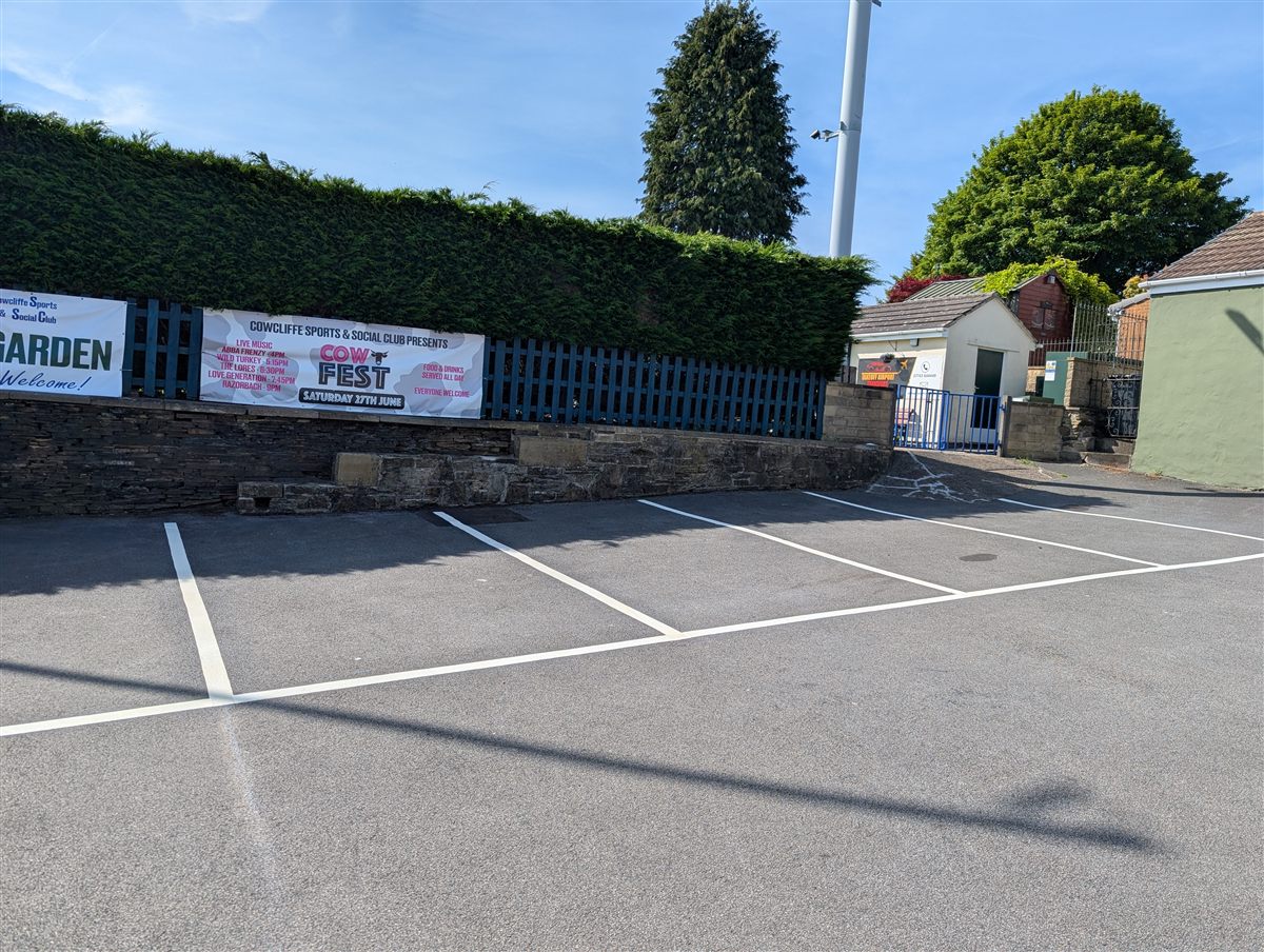 Fresh white thermoplastic parking bay lines at Cowcliffe Club car park in Huddersfield